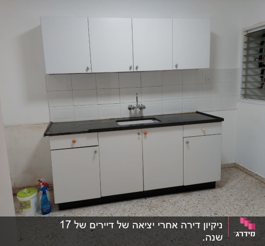 ארונות מטבח עם חומרי ניקוי על הרצפה